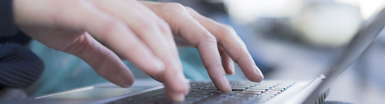 Un recruteur rédige un email depuis son ordinateur pour demander un renseignement.