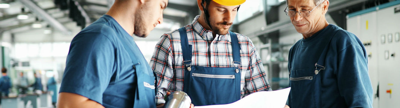 Un opérateur de production et son équipe vérifient la production en usine.